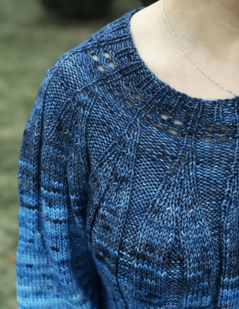 Close up photo showing a blue textured sweater on a woman
